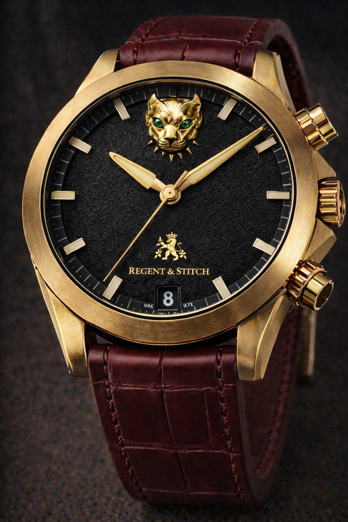 Luxury watch with gold case, black dial, and maroon leather strap on a dark background